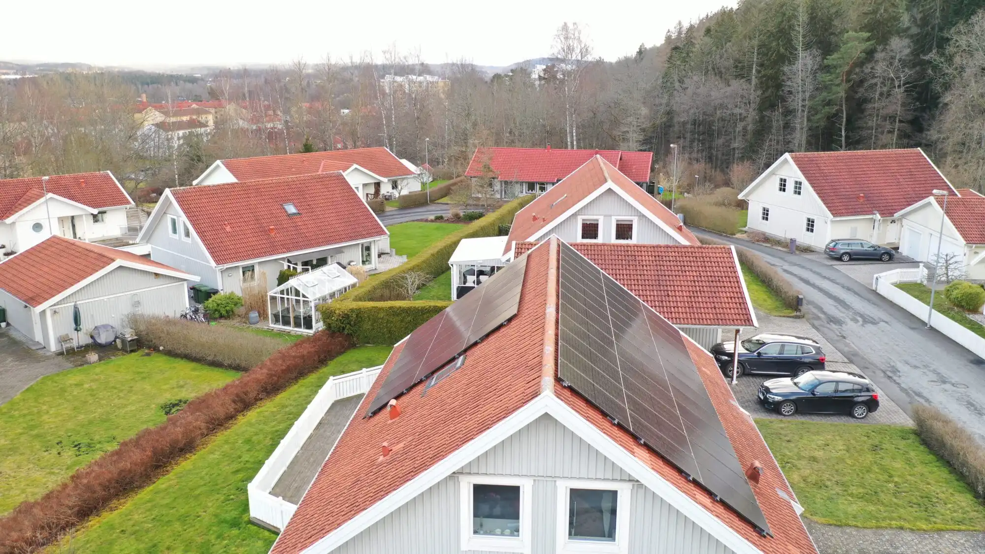 Solcellsanläggning på rött hustak i villaområde